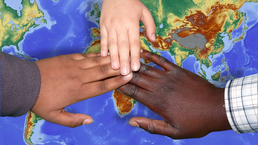 Kinderhände auf einer Weltkarte
