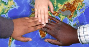 Kinderhände auf einer Weltkarte