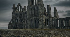 Gotische Schlossruine mit verwildertem Friedhof