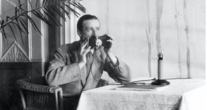 Alan Gordon-Finlay modelliert das Hush-a-Phone , ein „abgeschirmtes“ Mikrofon, das akustische Störungen bei der Simultanübersetzung eliminieren soll, um 1927 