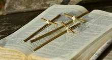 Aufgeschlagene Bibel mit drei kleinen Holzkreuzen