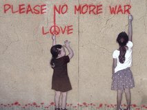 Straßenkunstwerk: Zwei Mädchen schreiben Friedenswunsch auf Mauer