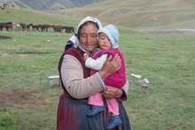 Eine Nomadin mit ihrem Enkel in den Bergen von Kirgistan